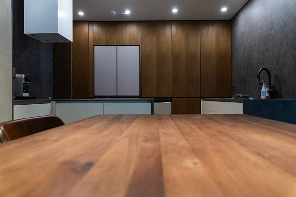 Empty wooden table with the bright white interior of the kitchen as a blurred background
