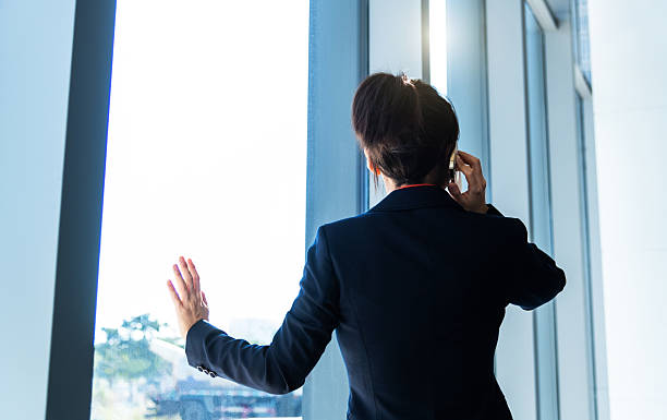 istock Businesswoman using smart phone near the window 2221723695