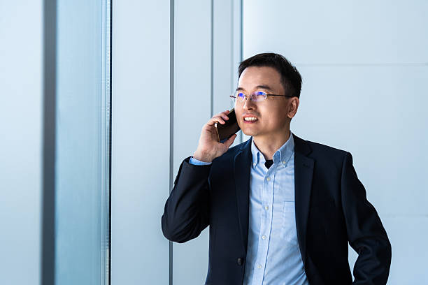 istock Businessman using smart phone near the window 2221724116