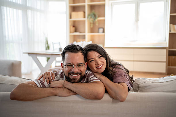 istock Happy couple relaxing together on sofa at home smiling 2221724501