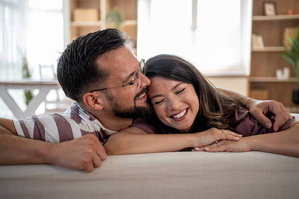 istock Young couple relaxing and embracing on sofa at home 2221724640