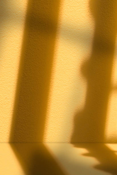 istock Light and shadow on orange background.Studio background with window light on yellow podium with natural abstract sunbeams for Autumn banner,Blank interior yellow wall and floor Fall product display 2221725262