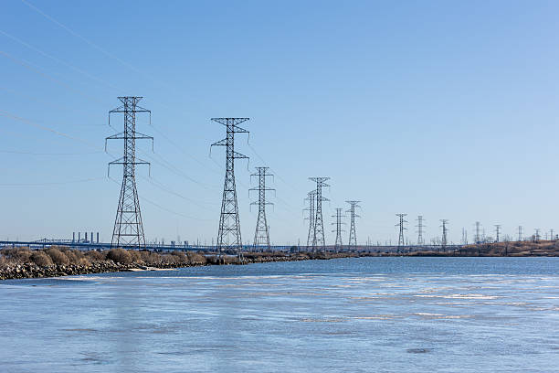 istock Frozen Pond and Power Towers Under Clear Blue Winter Sky 2221727844