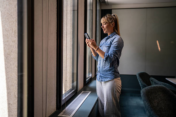istock Executive Woman Checking Phone in Corporate Boardroom 2221729768