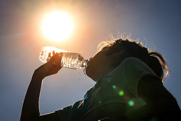istock Young woman drinking water under the summer sun 2221739885