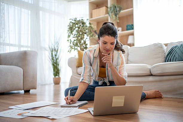 istock Focused young woman taking notes while working from home 2221743120