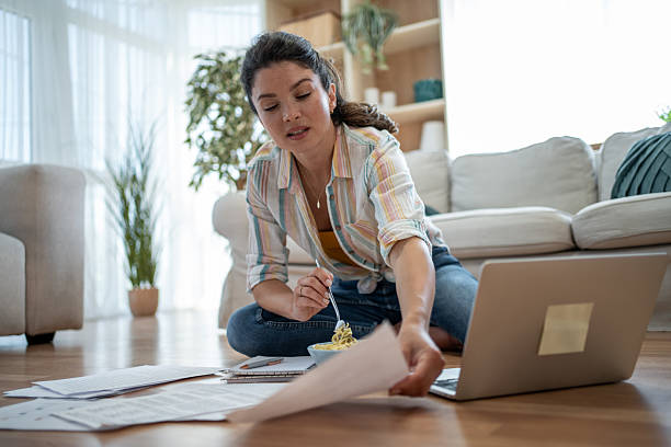 Young woman working from home and having lunch at the same time