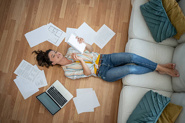 istock Young woman relaxing on the floor with documents and laptop after work 2221743210