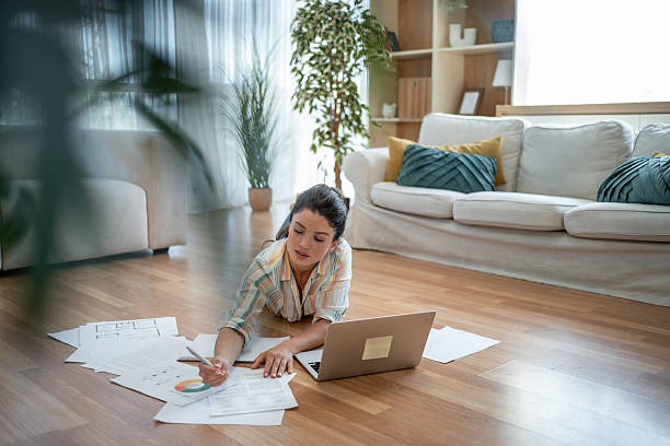 istock Focused young woman working from home analyzing charts and documents 2221743243