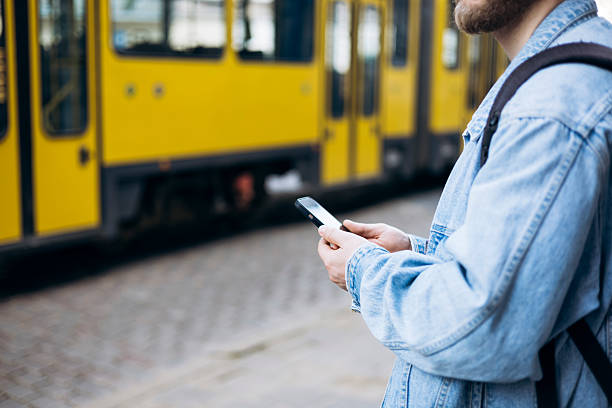 istock Man waiting at public transport stop using smartphone during daytime, copy space. 2221744713