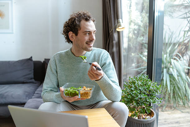 istock Man enjoying a healthy meal while sitting by the window at home 2221746145