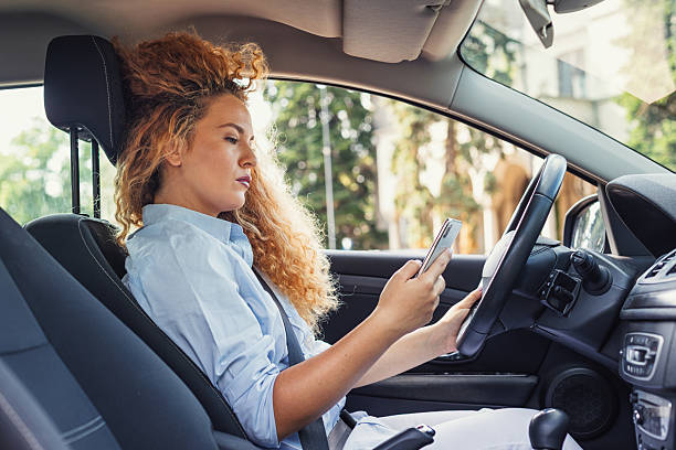 istock Beautiful woman being distracted whilst driving 2221746529