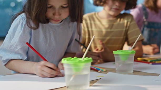 istock Artclass girl drawing pencil sitting table with classmates engaged work closeup. 2221748595