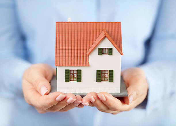 istock Toy house in hands 2221750475