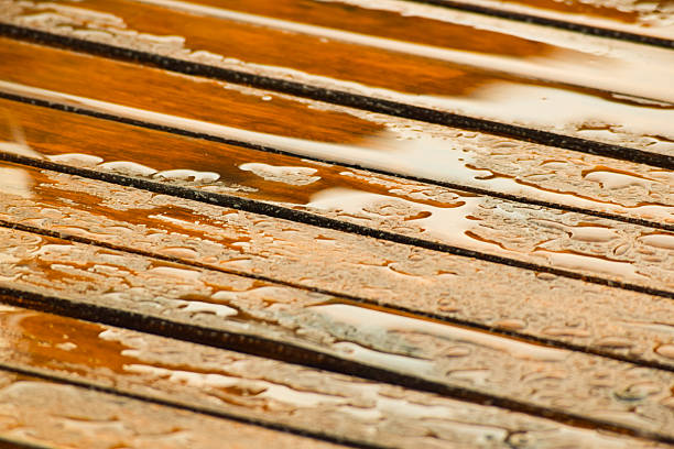 istock Partial view of wooden slatted table with raindrops 2221751009