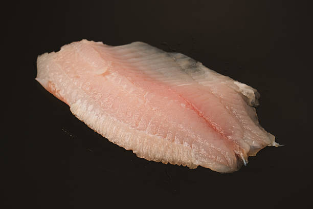 istock Fresh tilapia fillet on black background, top view. 2221753313