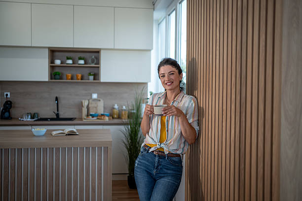 istock Smiling woman enjoying morning coffee in modern kitchen 2221756691