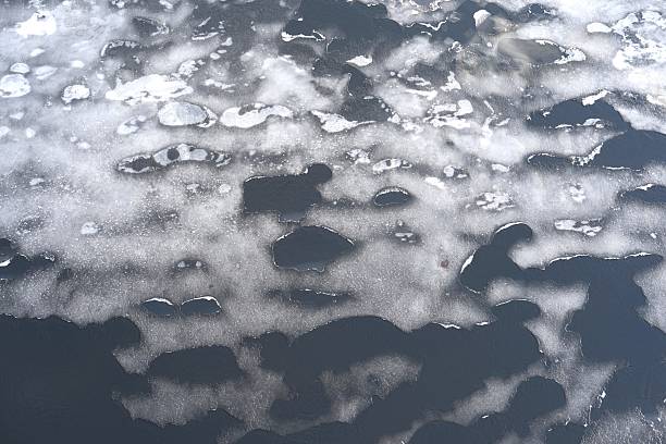 istock Body of river water with melting patchy ice and snow on its surface, creating an abstract texture. Thawing and melting ice layer, changing seasons, transition in nature. Textures 2221756738