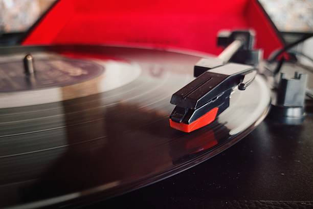 istock Close-up view of a vinyl record spinning on a turntable with red felt 2221764668