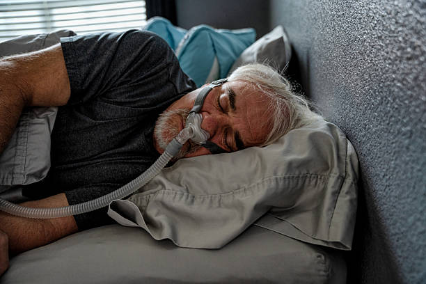 istock A 60-year-old man sleeps with a CPAP machine in bed. The machine helps him breathe more easily and prevents sleep apnea, a common sleep disorder 2221771802