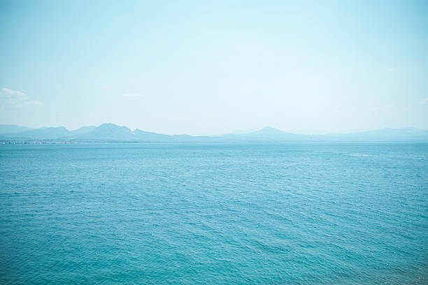 istock Calm blue sea with distant mountains under clear sky in Greece 2221774217