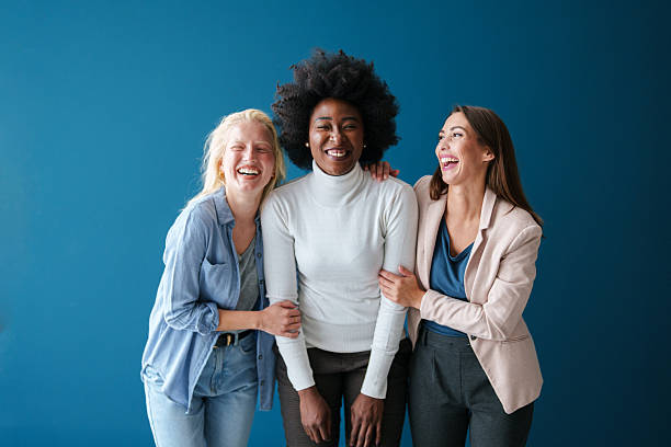 istock Three Multicultural Friends Laughing Together Against a Vibrant Blue Backdrop 2221779955