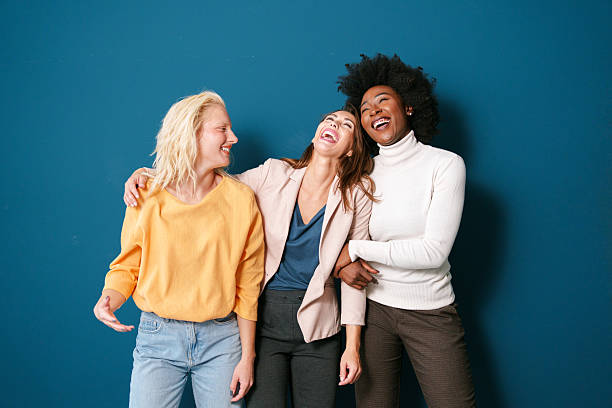 istock Cheerful Multicultural Friends Laughing Together Against a Vibrant Blue Background 2221779966