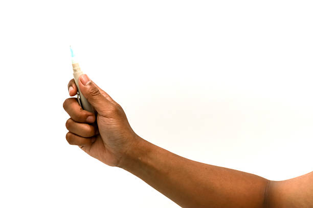 istock Close-up of hand holding lancet device for blood sugar testing on white background 2221782243