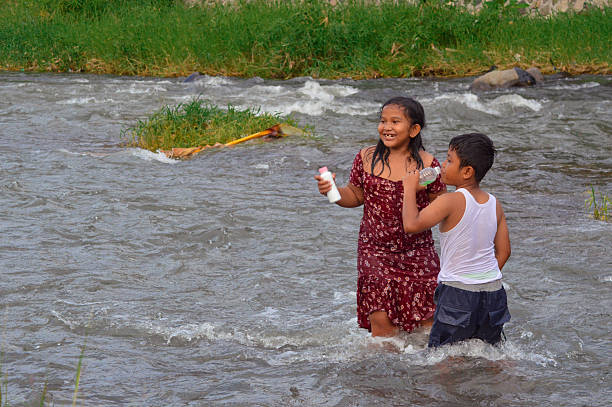 Children having fun refreshing in the river on hot summer day