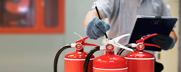 istock Fire extinguisher has hand engineer inspection checking pressure gauges to prepare fire equipment for protection and prevent emergency and safety rescue and alarm system training concept. 2221786724