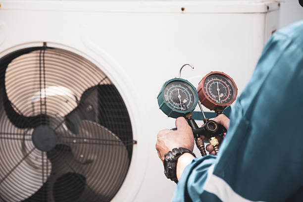 istock Heat and Air Conditioning, HVAC system service technician using measuring manifold gauge checking refrigerant and filling industrial air conditioner after duct cleaning maintenance outdoor compressor. 2221786850