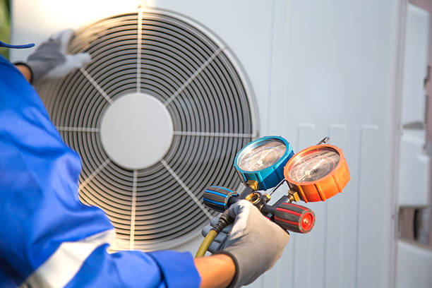 istock Heat and Air Conditioning, HVAC system service technician using measuring manifold gauge checking refrigerant and filling industrial air conditioner after duct cleaning maintenance outdoor compressor. 2221786866