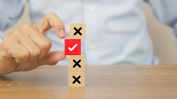 istock Hand choose check mark on cube wooden toy block stack with cross symbol for true or false changing mindset or way of adapting to change leader and transform quiz answer and poll concept 2221786879