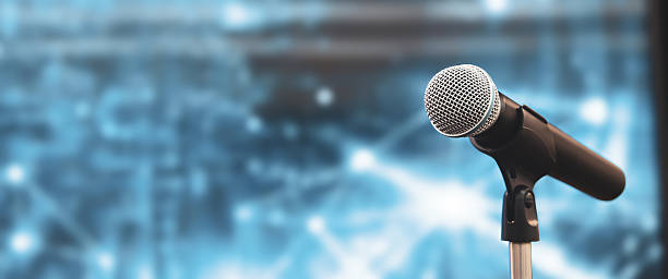 istock Microphone Public speaking background, Close up microphone on stand for speaker speech presentation stage performance or press conference background. 2221787734