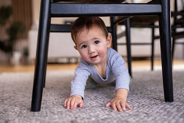 istock Baby Crawling Under Dining Chair and Looking Up 2221789622