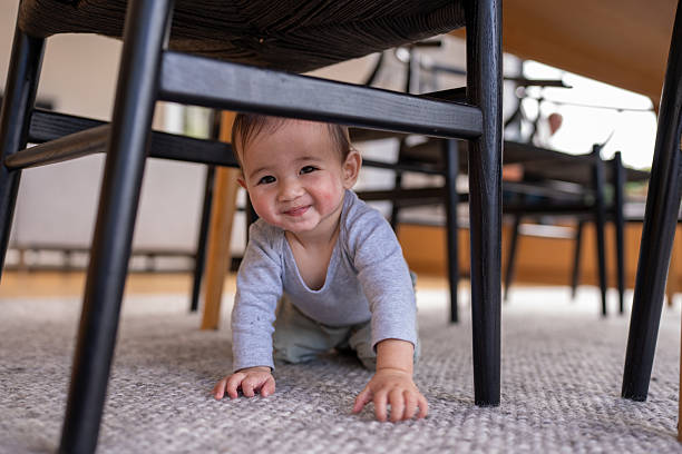 istock Smiling Baby Crawling Under Dining Chair 2221789629