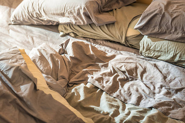 istock Unmade bed with rumpled sheets in natural daylight 2221790399