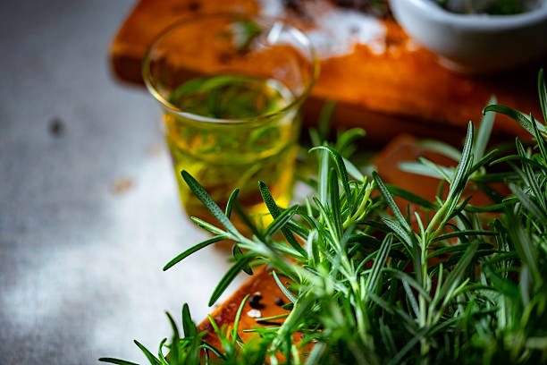 Fresh rosemary, rock salt, and olive oil on a cutting board, perfect for culinary themes.
