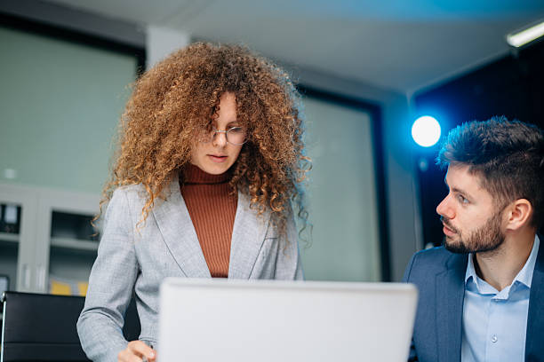 istock Professional man and woman reviewing printed business documents in modern office setting. Concept of teamwork, consulting, planning 2221793066