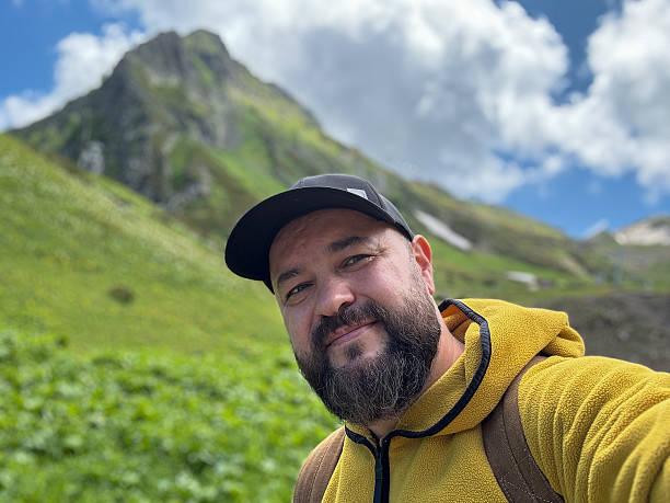 istock Hiker Smiles in Green Mountain Landscape Under Bright Blue Sky 2221793745
