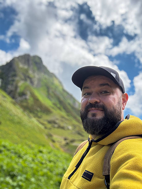 istock Man Enjoying Outdoors During a Sunny Mountain Hike in Scenic Nature 2221793783