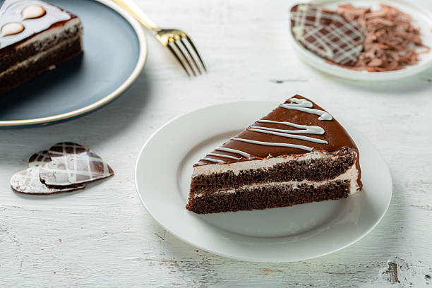istock Chocolate cake slice with milk cream layers, Western dessert, white background. 2221797628