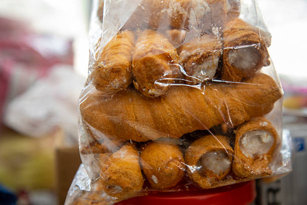 Golden Brown Cream Rolls Wrapped in Plastic on Indian Shop Counter