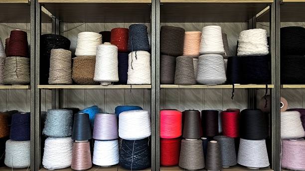 istock Multicolored Yarn Cones for Textile Production. Assorted Yarn Cones in Various Shades and Textures. 2221802218