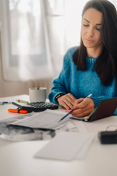 istock Accountant calculating tax using calculator and taking notes at home office desk 2221803254