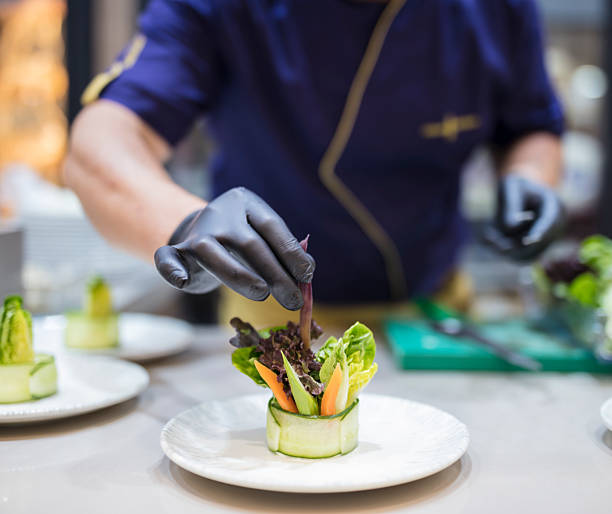 istock Male Cook preparing salad plates in a luxury restaurant kitchen. 2221803696