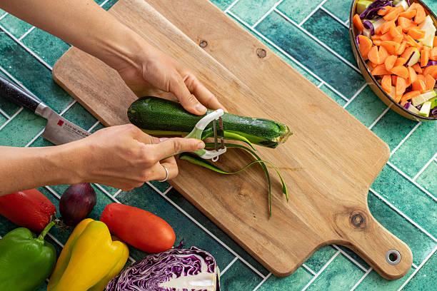 istock Woman Peeling Fresh Zucchini in a Stylish Kitchen Environment 2221804812