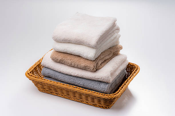 istock Folded Towels Stacked in Basket on White Background 2221806119