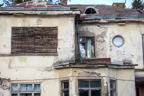 istock .an old, worn-out building facade with several windows and doors, indicating its abandonment or poor condition. 2221806536