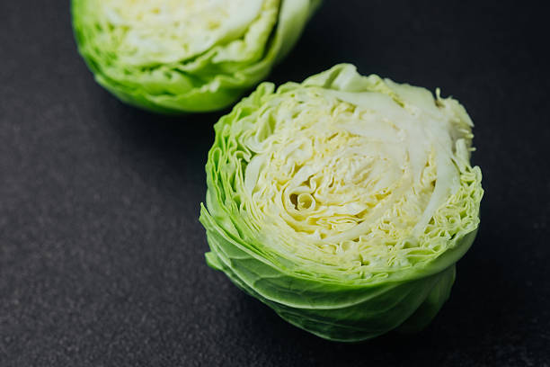 istock Two cut cabbage halves on dark background close detail 2221807085